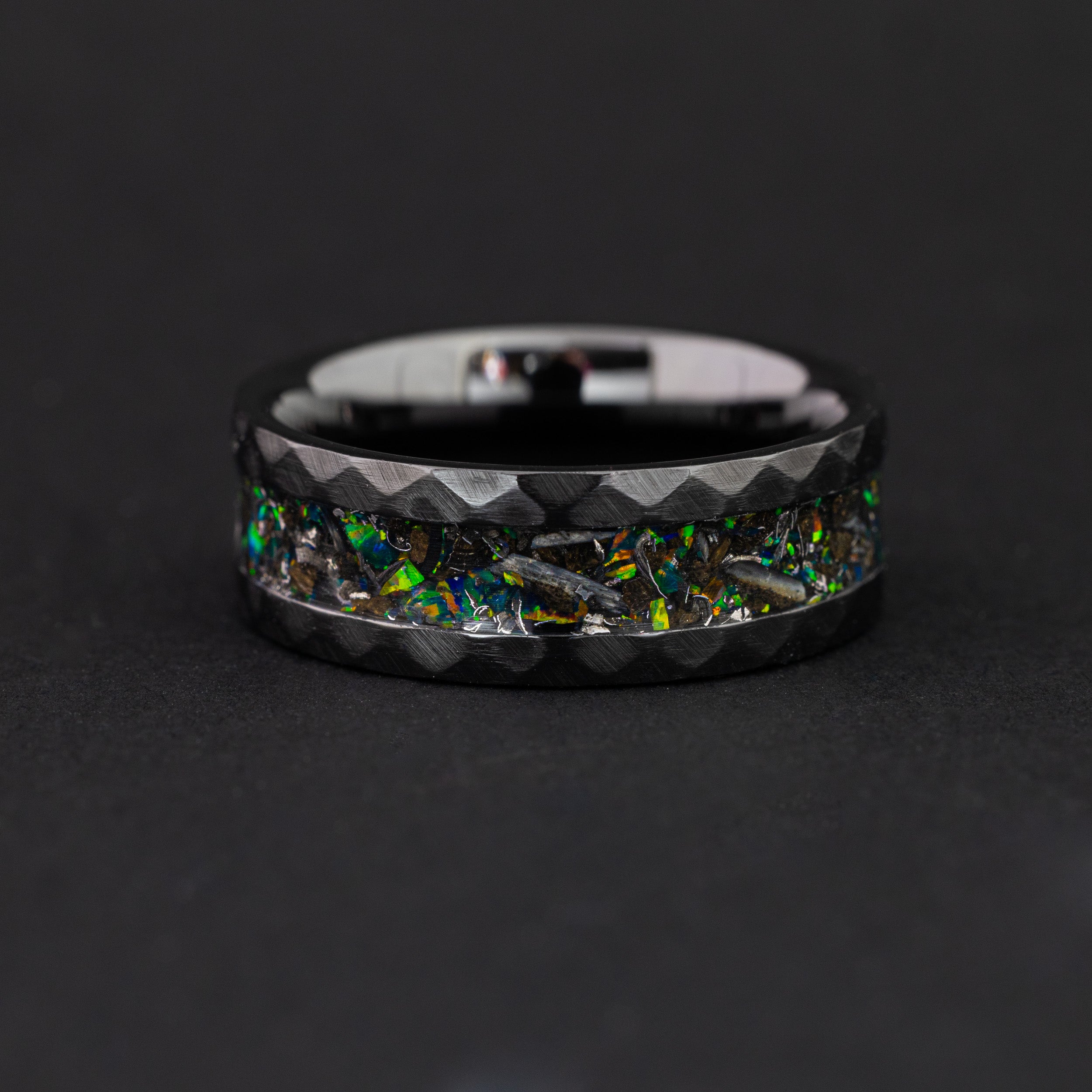 hammered black ceramic ring featuring authentic meteorite and vibrant green opals.