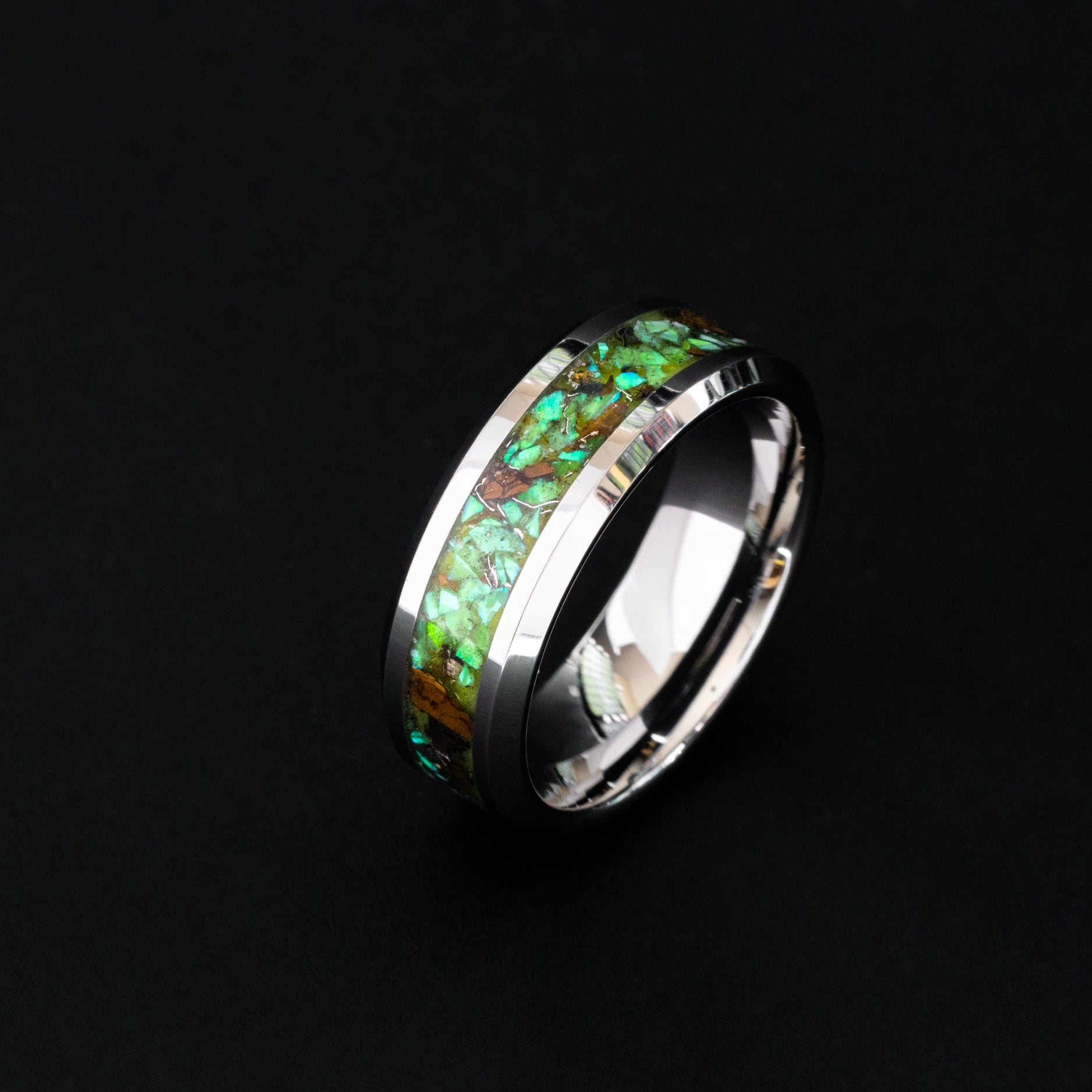 Handcrafted 8mm tungsten wedding band featuring prehistoric raptor bone and vibrant green glow.