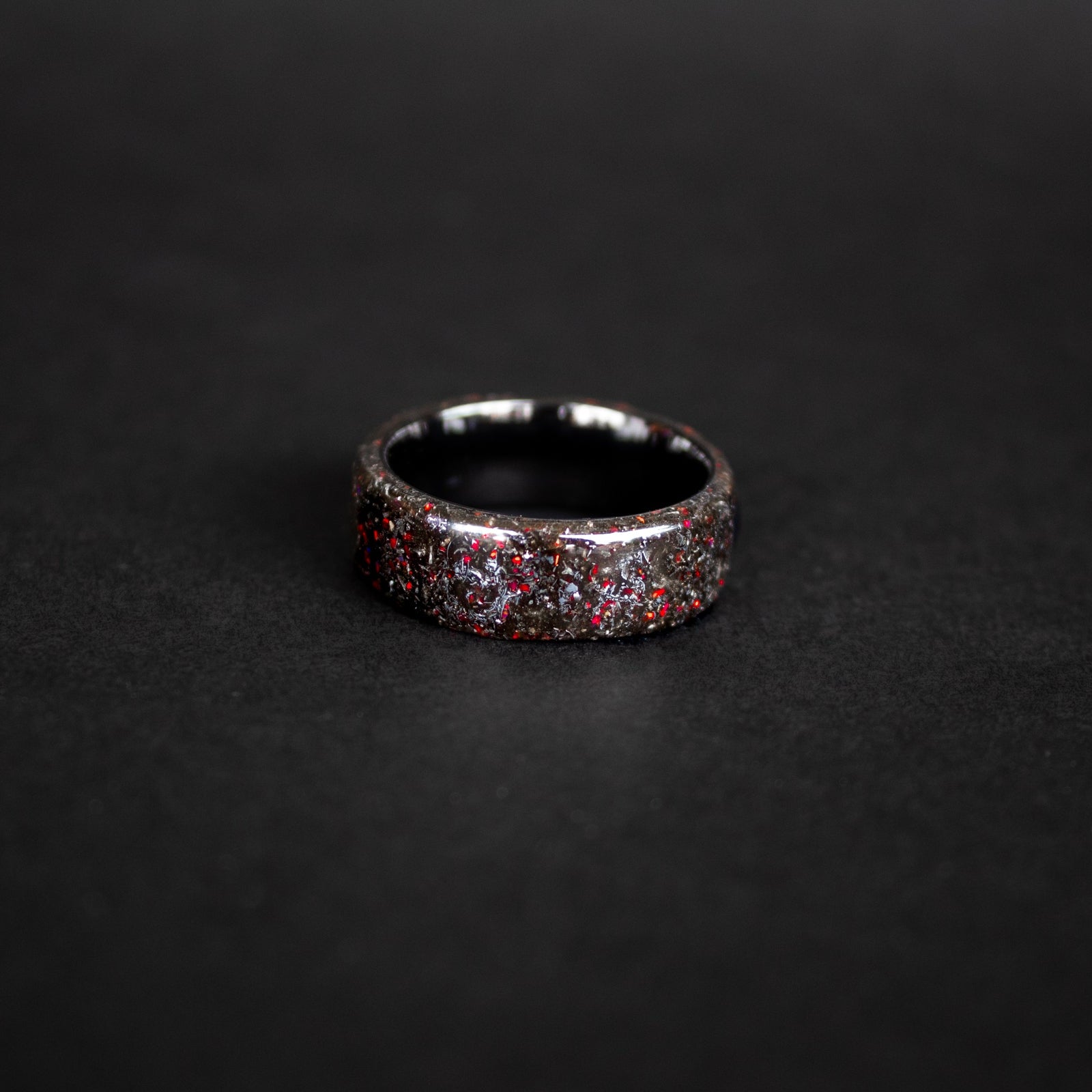Handcrafted endless black ceramic mens wedding band with authentic Campo del Cielo meteorite and red opal accents made in California