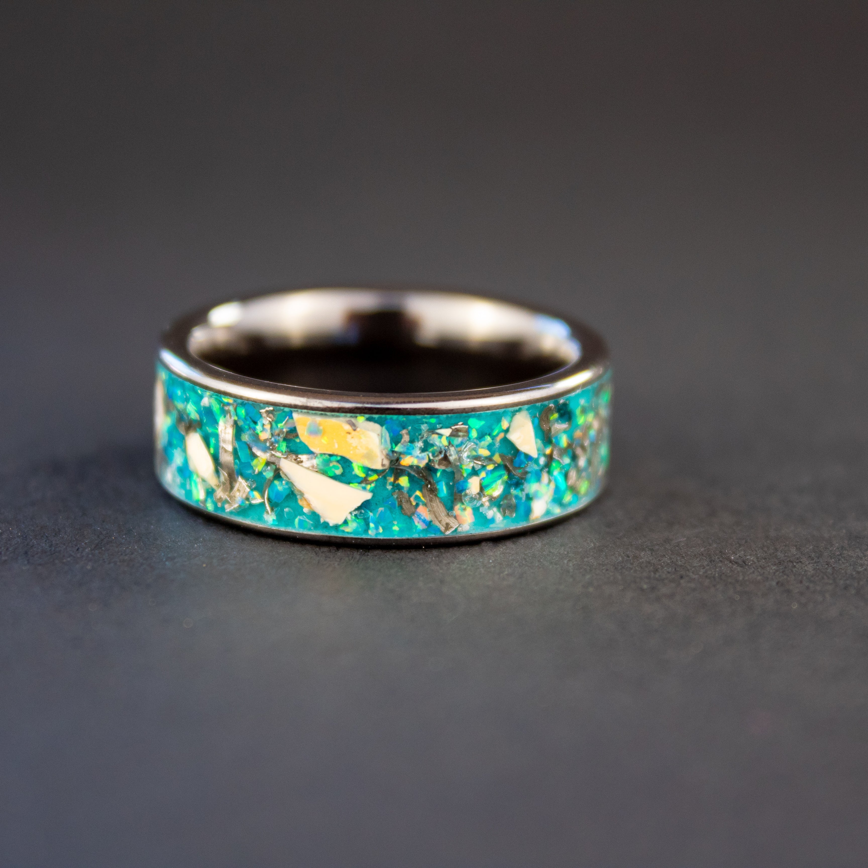 Handcrafted 8mm wide channel black ceramic mens wedding band with authentic Mosasaur bone and Campo del Cielo meteorite in oasis opal blue glow inlay made in California