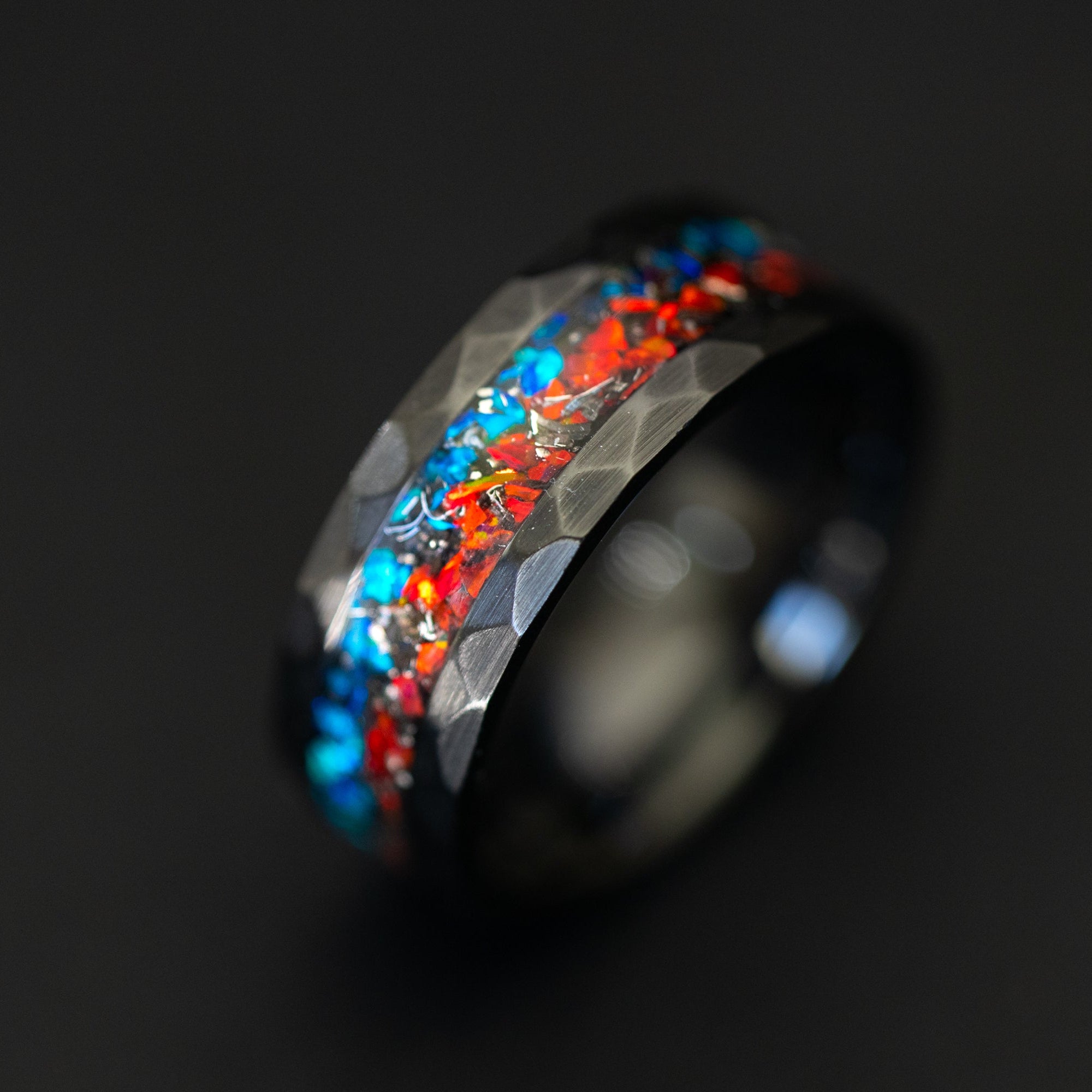 Handcrafted hammered black ceramic wedding band featuring celestial meteorite fragments and dual-tone opal.