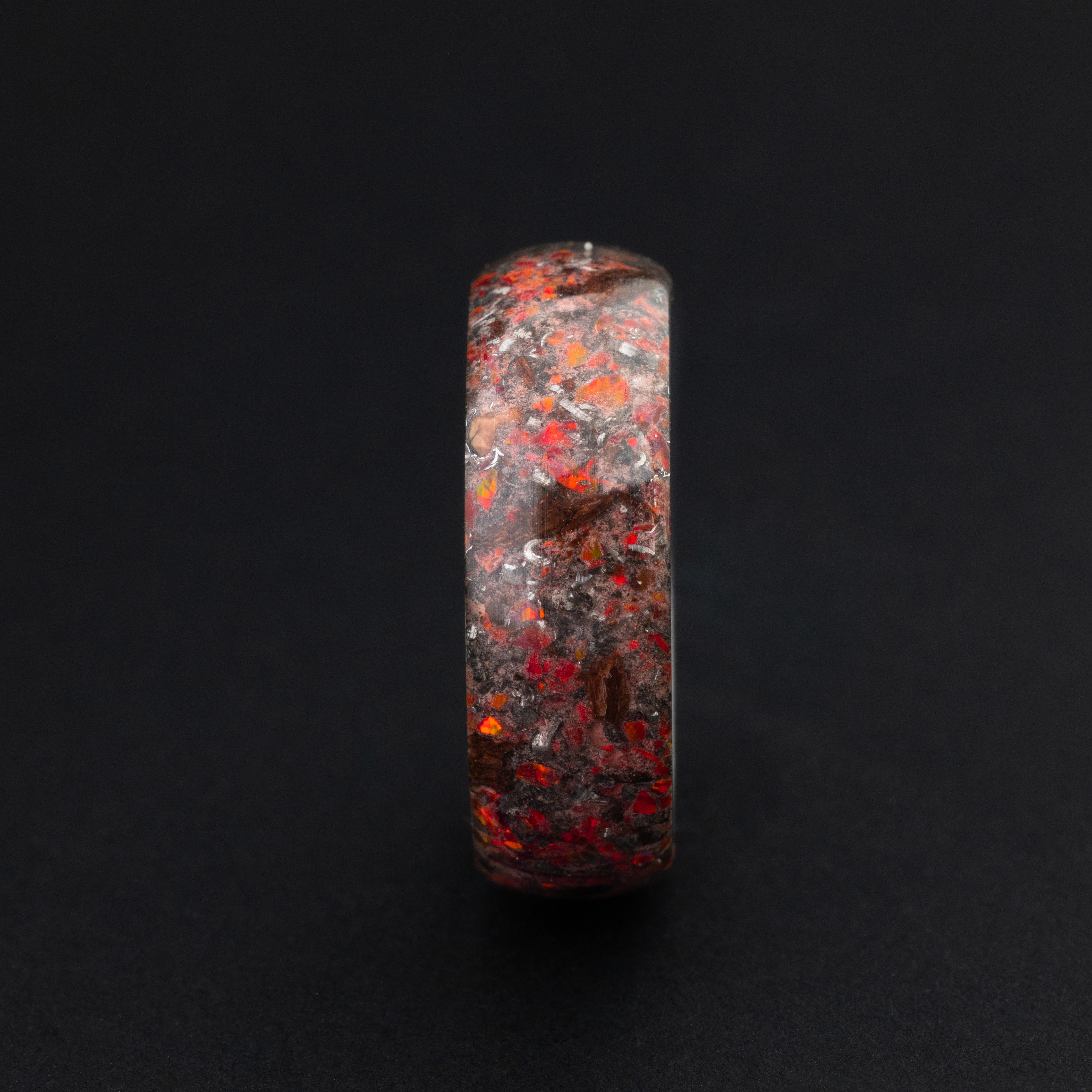 Endless tungsten ring featuring authentic prehistoric fossil and vibrant red glow-in-the-dark inlay.