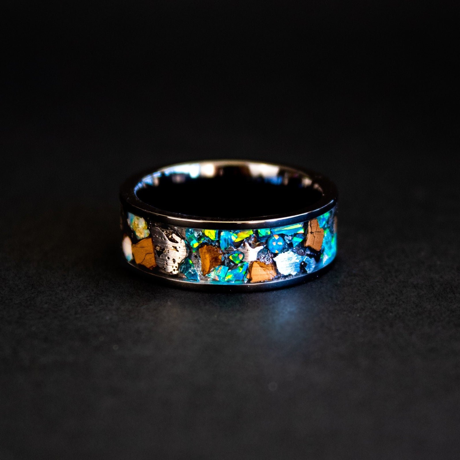 Handcrafted 8mm wide channel tungsten mens wedding band with large authentic T-Rex bone and Campo del Cielo meteorite pieces in blue and green opal inlay made in California