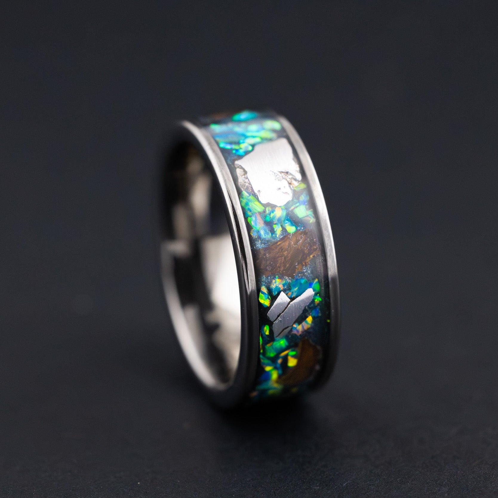 Handcrafted 8mm wide channel tungsten mens wedding band with large authentic Triceratops bone and Campo del Cielo meteorite pieces in green opal inlay made in California