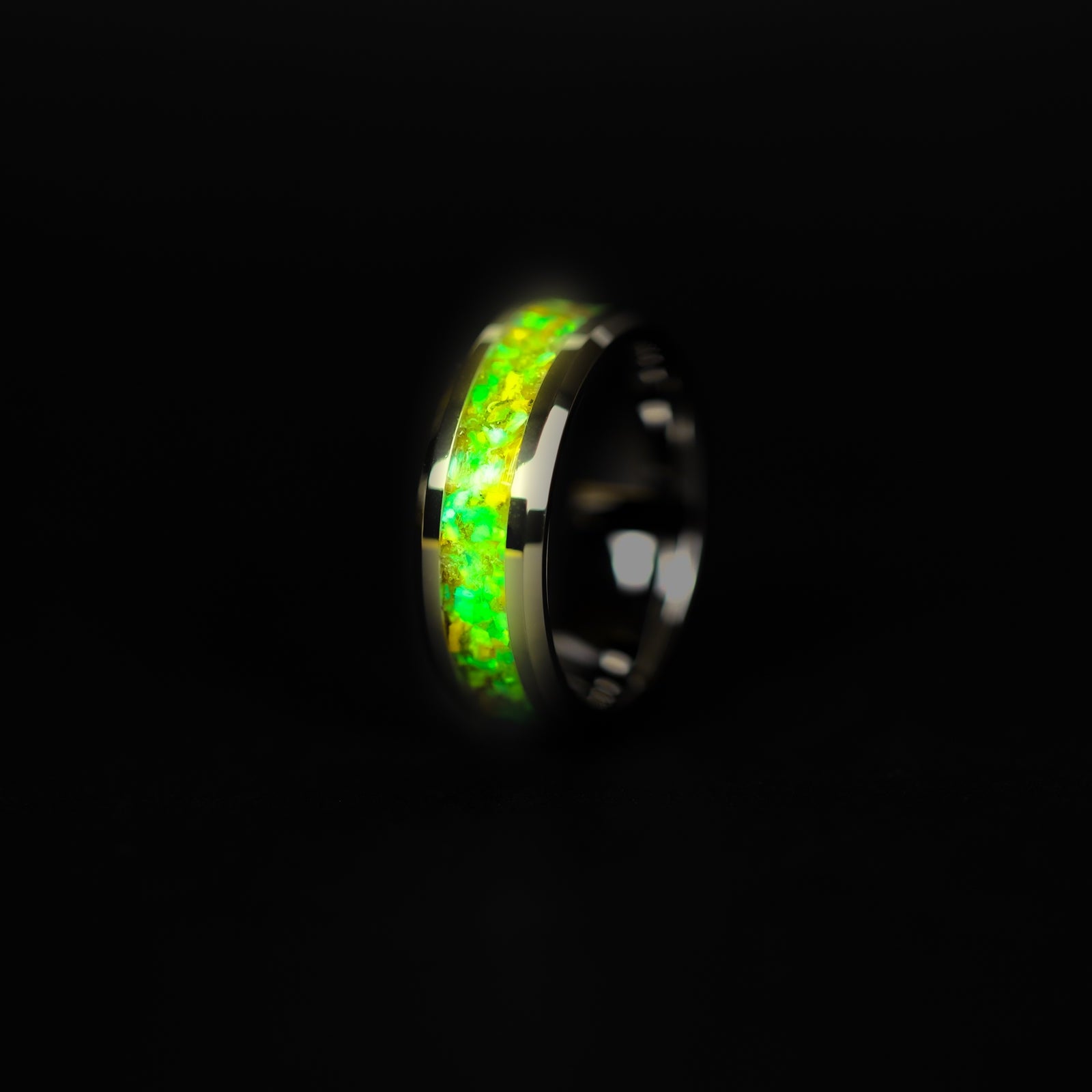 Close up of genuine Velociraptor fossil and Campo del Cielo meteorite shavings suspended in lime green opal inlay on tungsten 