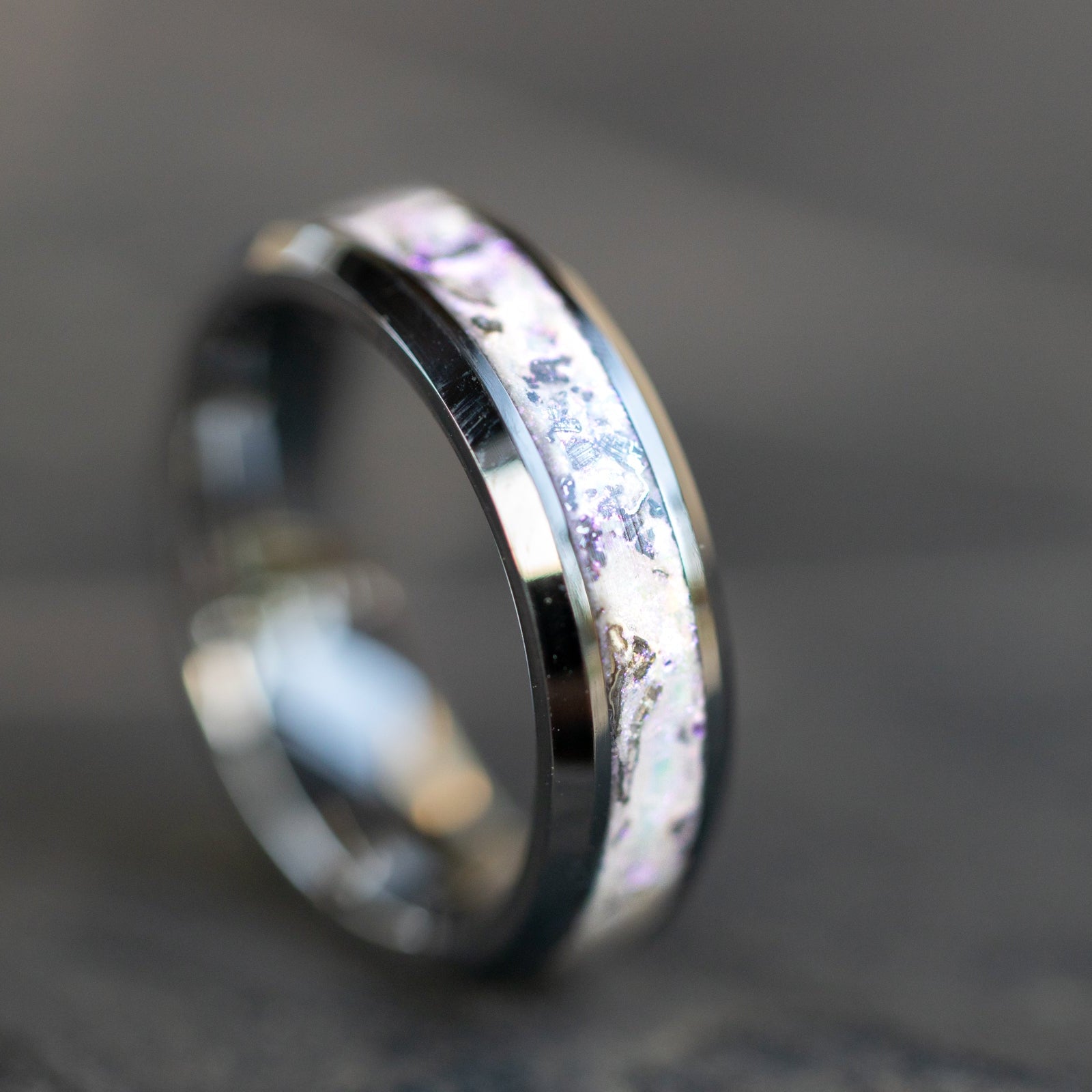 Detail shot of the White Pearl Meteorite ring showing authentic Campo del Cielo meteorite shavings catching light through soft white pearl glitter inlay with pink sheen